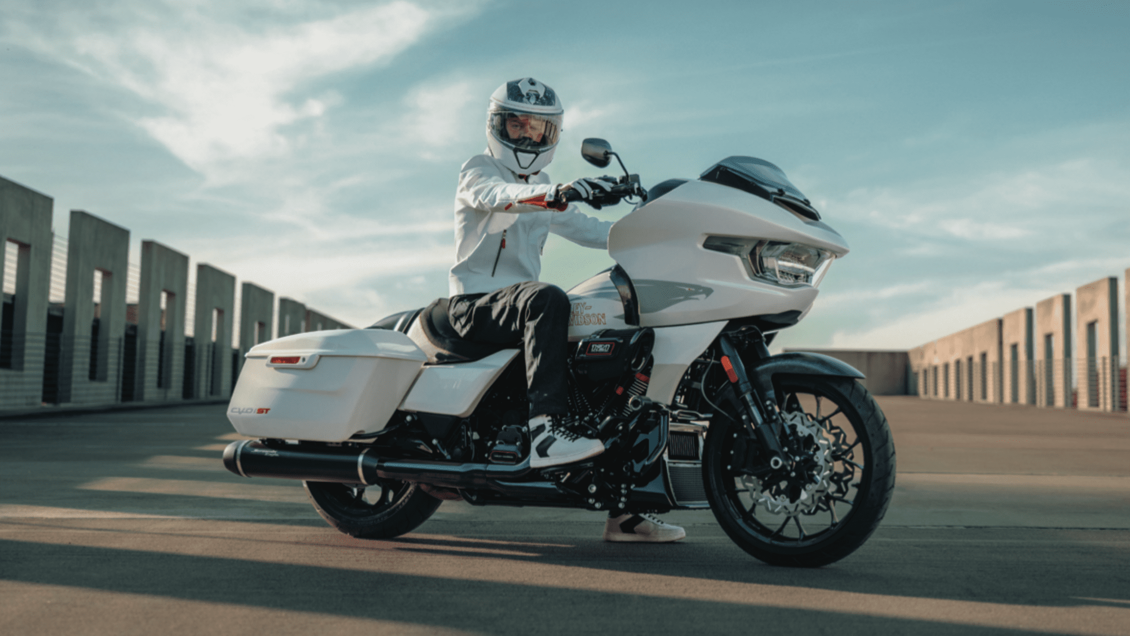 Rider on the 2024 Harley-Davidson® CVO™ Road Glide® ST parked in Ormond Beach, FL, with a modern urban backdrop.